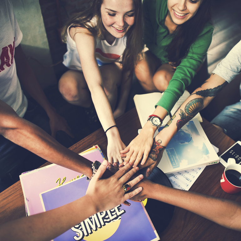 Kaiserschild Stiftung: Gruppe Studenten streckt die Hände zusammen